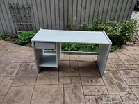 Solid wood desk front view showing flat surface and shelving underneath.