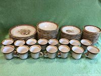 Full view of stacked dinner plates, salad plates, saucers, and arranged mugs showing the set composition