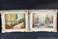 Both framed paintings side by side showing autumn forest path and winter river scenes.