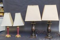 Pair of 28-inch Stiffel table lamps with dark wooden/bronze bases and rectangular off-white lampshades alongside a smaller pair of 21-inch brass-based table lamps with red stems and square white shades.