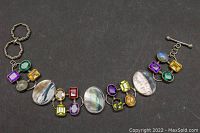 Top view of entire bracelet showing mother-of-pearl ovals and colored crystals.