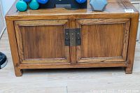 Closed view of antique wooden money chest showing two front doors with metal hardware