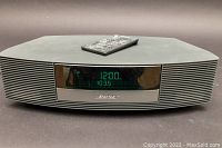 Front view of Bose Wave Radio II with remote control on top showing LED display
