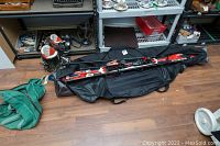 Rossignol skis with bindings, Lange ski boots next to black ski bag on wooden floor