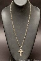 Full view of the sterling silver necklace with cross pendant on display bust.