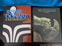Two hardcover books shown front covers: Jesse Oonark: A Retrospective with stylized artwork, and Grasp Tight The Old Ways with an image of a carved hand holding a tool.