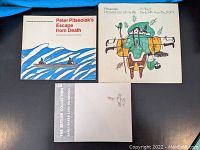 Three Inuit art books on blue background, showing covers of all three books.