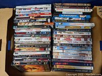 Top view of 42 DVDs in two stacks showing titles like Star Wars, The Thin Red Line, Michael Clayton, Amistad and more