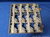 Closed view of antique metal bunny mold, showing outer metal surface and hinges