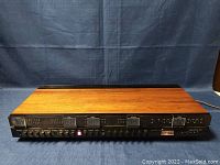 Front view showing wood veneer top and black front panel