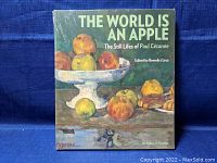 Front cover of the sealed hardcover art book showing a still life painting with apples and the title text.