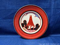 Front view of the round Clarice Cliff Bizarre plate showing red border and colorful stylized design