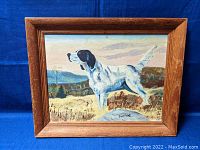 Framed painting showing full dog and landscape background