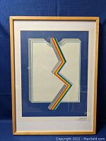 Front view of framed print showing abstract design, wood frame and mat.