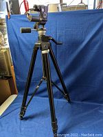 Full view of black aluminum tripod with extended legs and mounted pan-tilt head