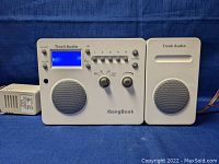 Front view of Tivoli Audio iSongBook main radio unit with blue LCD display and matching external speaker