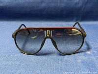 Front view of vintage Carrera Champion sunglasses showing black frame with red accent and gradient lenses with Carrera logo on left lens.