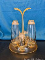 Front view of the vintage Fratelli Guzzini acrylic and glass cruet set with bottles and frosted yellow stand.