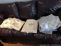 Four grey curtain panels folded and stacked with sizes visible on label 52x92 inches each, accompanied by four cream panels.