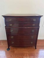 Full view of Gibbard wood dresser showing five graduated drawers with brass drop handles and wood finish.