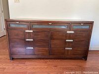 Front view of dresser showing nine drawers and metal pulls