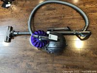 Overall view of canister vacuum, hose, wand and power head laid out on floor