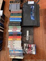 Photo showing multiple DVD sets including The West Wing, The Sopranos, The Big Bang Theory, Game of Thrones, Dexter, and a few hockey DVDs, with one Sony electronic device on the right side of the image