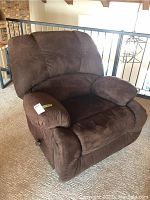 Side-angle view of the brown suede upholstered rocking recliner showing plush armrest and deep cushioned seat.