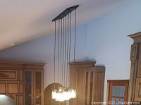 Another front view of the light fixture from a different angle, showing the fixture in place in a kitchen area with cabinetry.