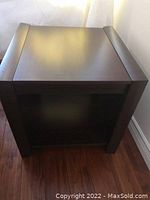 Top view of dark wood cube end table with raised vinyl veneer edges.