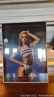 Full view of the framed poster featuring Karen Witter in 1984, showing her pose, outfit, and background.