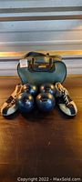 Full set showing four Starline black candlepin bowling balls, bowling shoes, and green carry bag.
