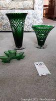 Three green glass pieces on carpet - two etched vases and one leaf shaped dish