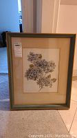 Framed watercolor painting showing hydrangea flowers inside rustic frame with matte.