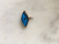 Top view of blue evil eye pendant showing marquise shape and metal loop bail.