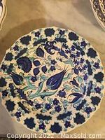 Front view of the plate showing the full design and scalloped edges with floral motifs.