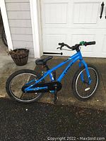 Side view of the full blue Trek kids' bike showing frame length, tires, seat, and pedals.