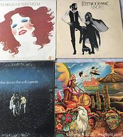 Photo of four vintage vinyl LP album covers: Bette Midler's The Divine Miss M, Fleetwood Mac's Rumours, The Doors' The Soft Parade, and Evolution.