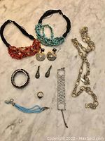 Overview of all jewelry items including chain belt, chokers, two pairs of earrings, ring, Swarovski crystal bracelet, and turquoise bracelet