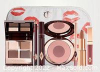 Complete 7-piece Charlotte Tilbury Sophisticate makeup kit displayed with accompanying lip print makeup bag.