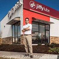 Exterior view of Jiffy Lube service center with staff member standing outside