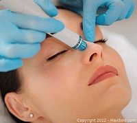 Photo showing a facial treatment device applied to a woman's nose area during a skincare procedure.