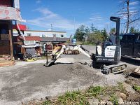 Bobcat mini excavator moving gravel at outdoor job site