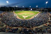 Wide-angle view of Ottawa Stadium baseball field at dusk with full stands and illuminated lights