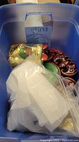 Photo of plastic tote containing Asian decor and figurines, some wrapped in tissue and plastic bags