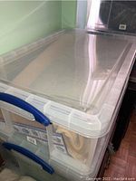 Closed plastic storage bin containing the bedding items