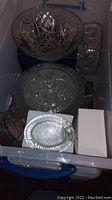 Top view showing large crystal bowl, medium bowl, smaller bowls, and metal tray in storage container.