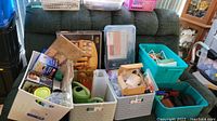 Wide shot of baskets and containers filled with assorted kitchenware and household items including pitchers, spice rack, and other miscellaneous supplies.