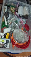 Overview of entire tote with assorted kitchenware items including graters, strainers, hand mixer, and other accessories.