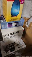 Photo showing stacked boxes with Mountain Gold Himalayan Salt Crystal SAD Clarity Lamp and Philips Café Royal 12-cup coffee maker
